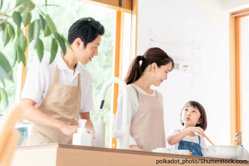 キッチンで一緒に料理をしているお父さん、お母さん、女の子