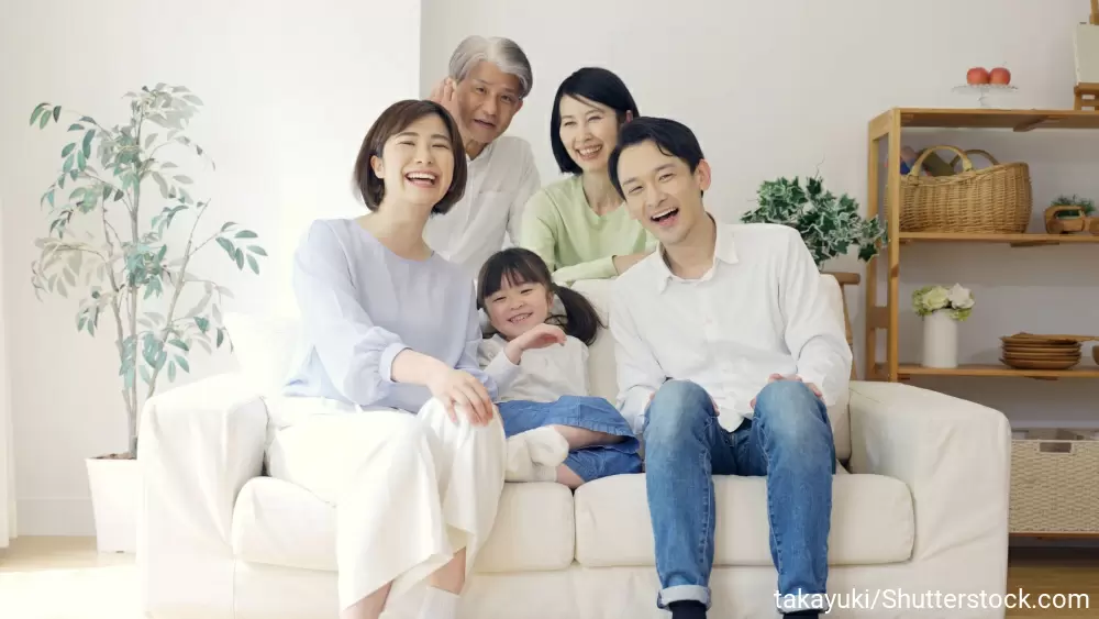 ソファに座って笑顔の女の子と両親、祖父母