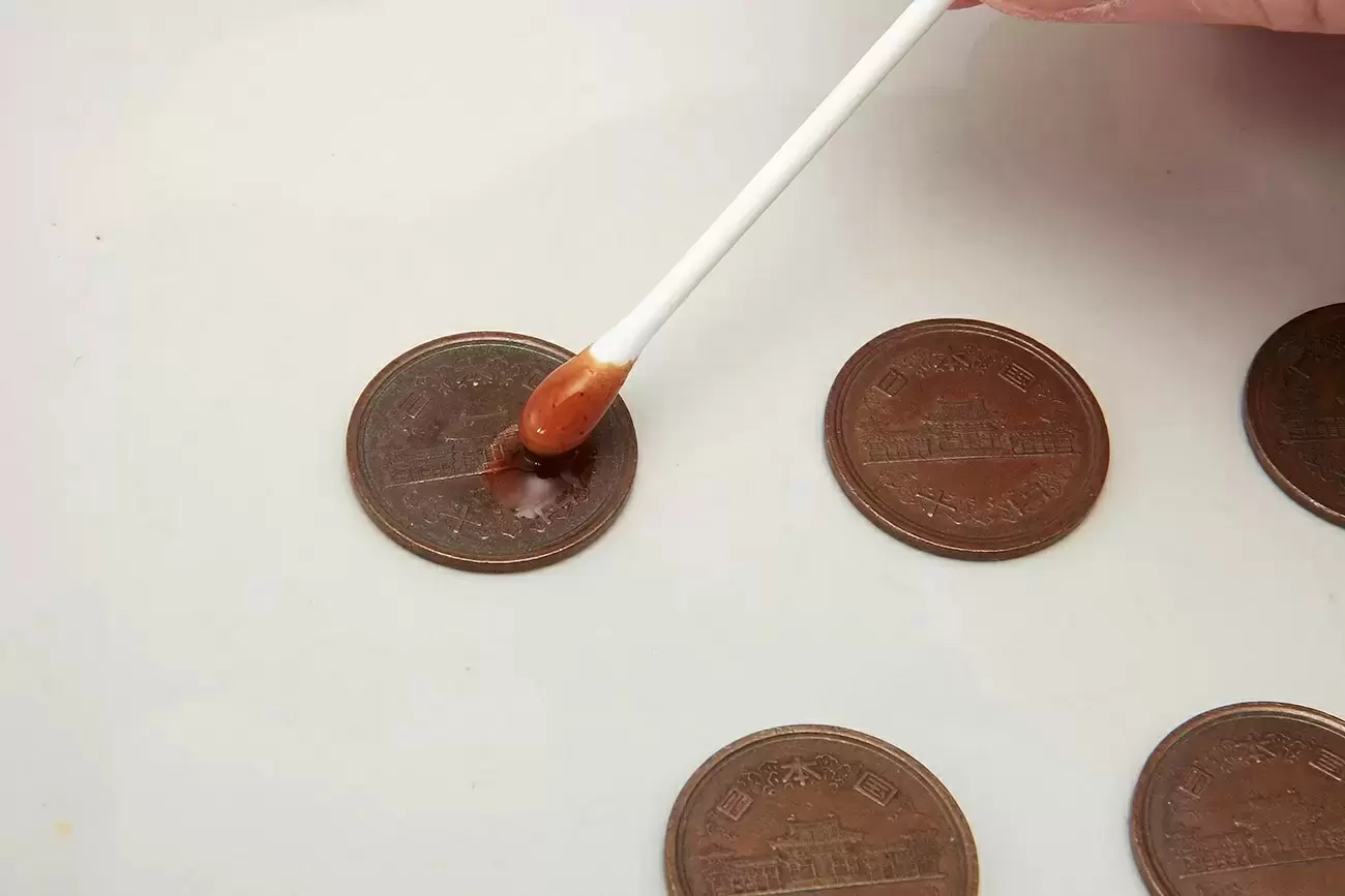 10円玉に綿棒でソースを塗っているところ