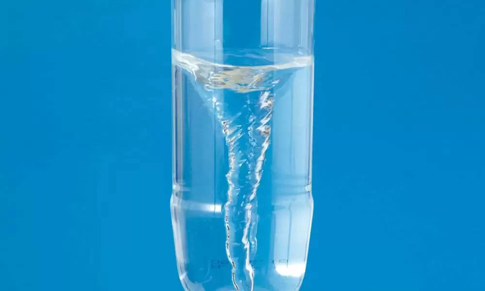 ペットボトルに入った水が、トルネード(竜巻)のように渦を巻いているところ