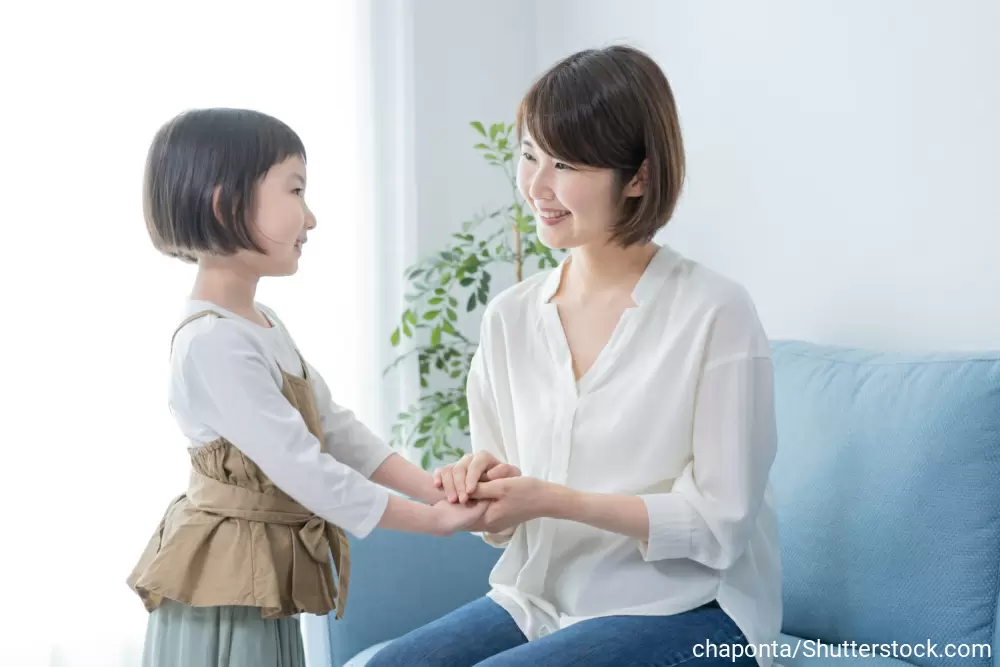 手を握り合いながら、笑顔で話す母娘
