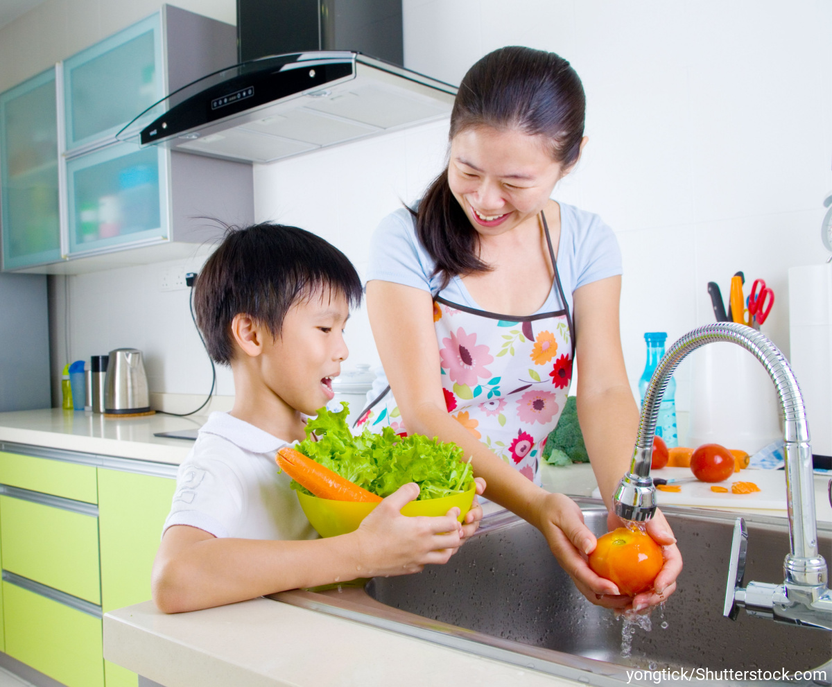 キッチンで野菜を洗うお母さんと息子