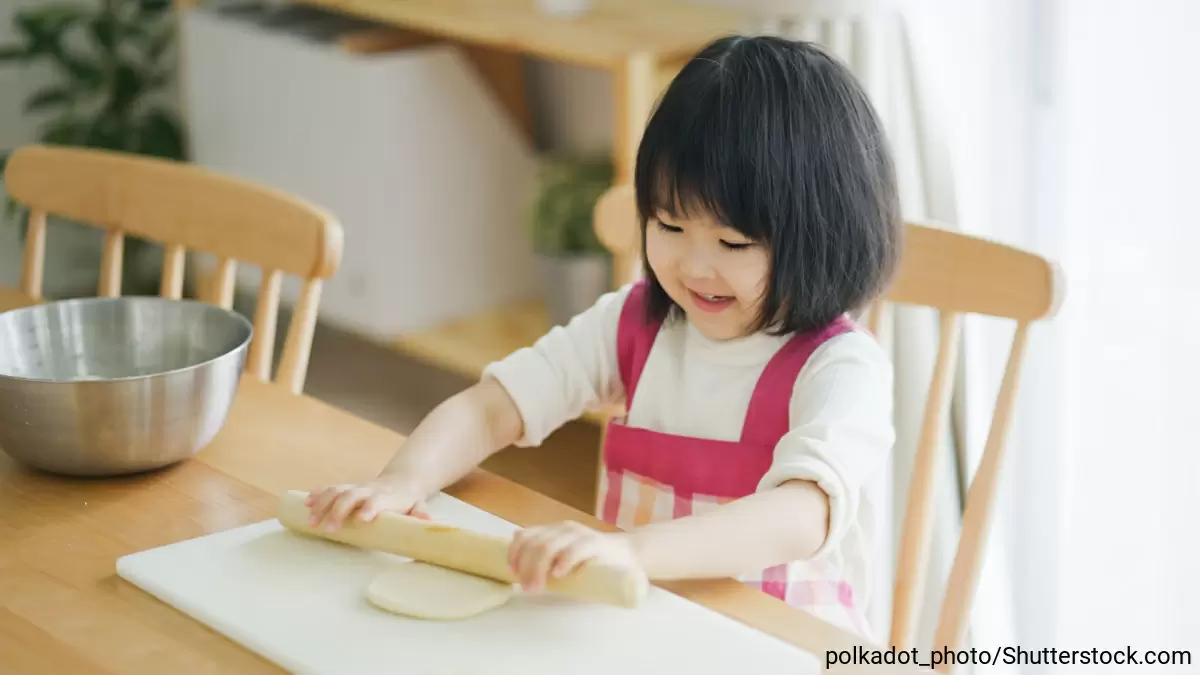 生地を伸ばしてお菓子をつくっている女の子