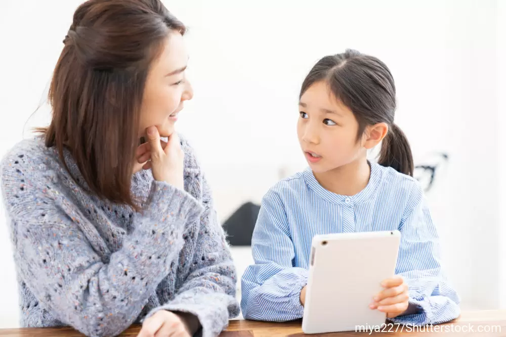 娘に笑顔で話しかける母親