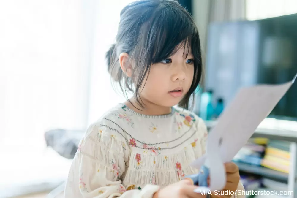ハサミで紙を切っている女の子
