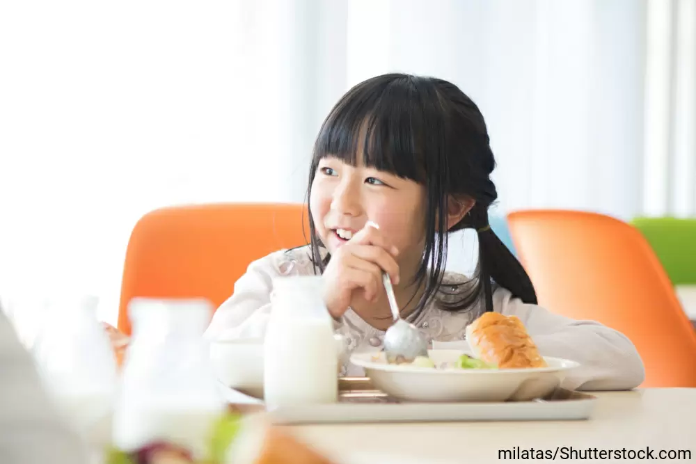 椅子に座ってお行儀よく食事をしている女の子