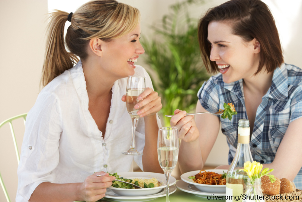 レストランで食事をしながら楽しそうに会話している二人の女性