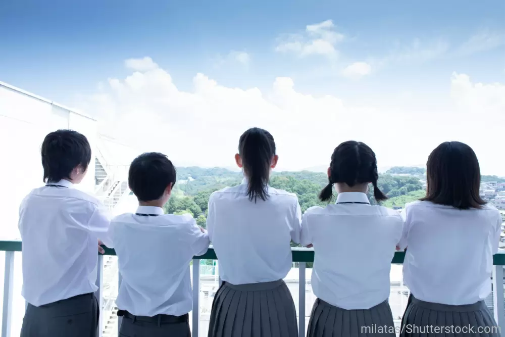 バルコニーに並んだ制服を着た5人の学生