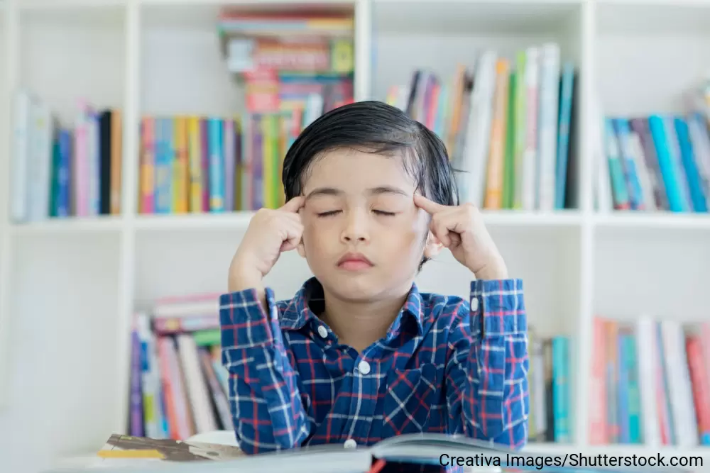目をつぶって指をこめかみにあて、何か思い返している様子の男の子