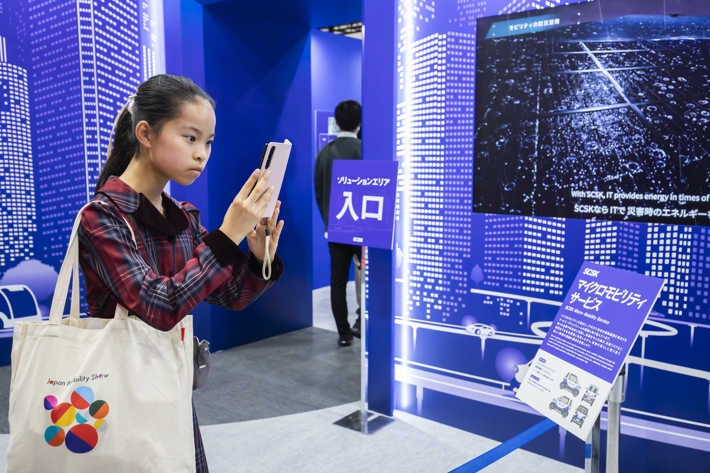 Japan Mobility Showで車を撮る中学生