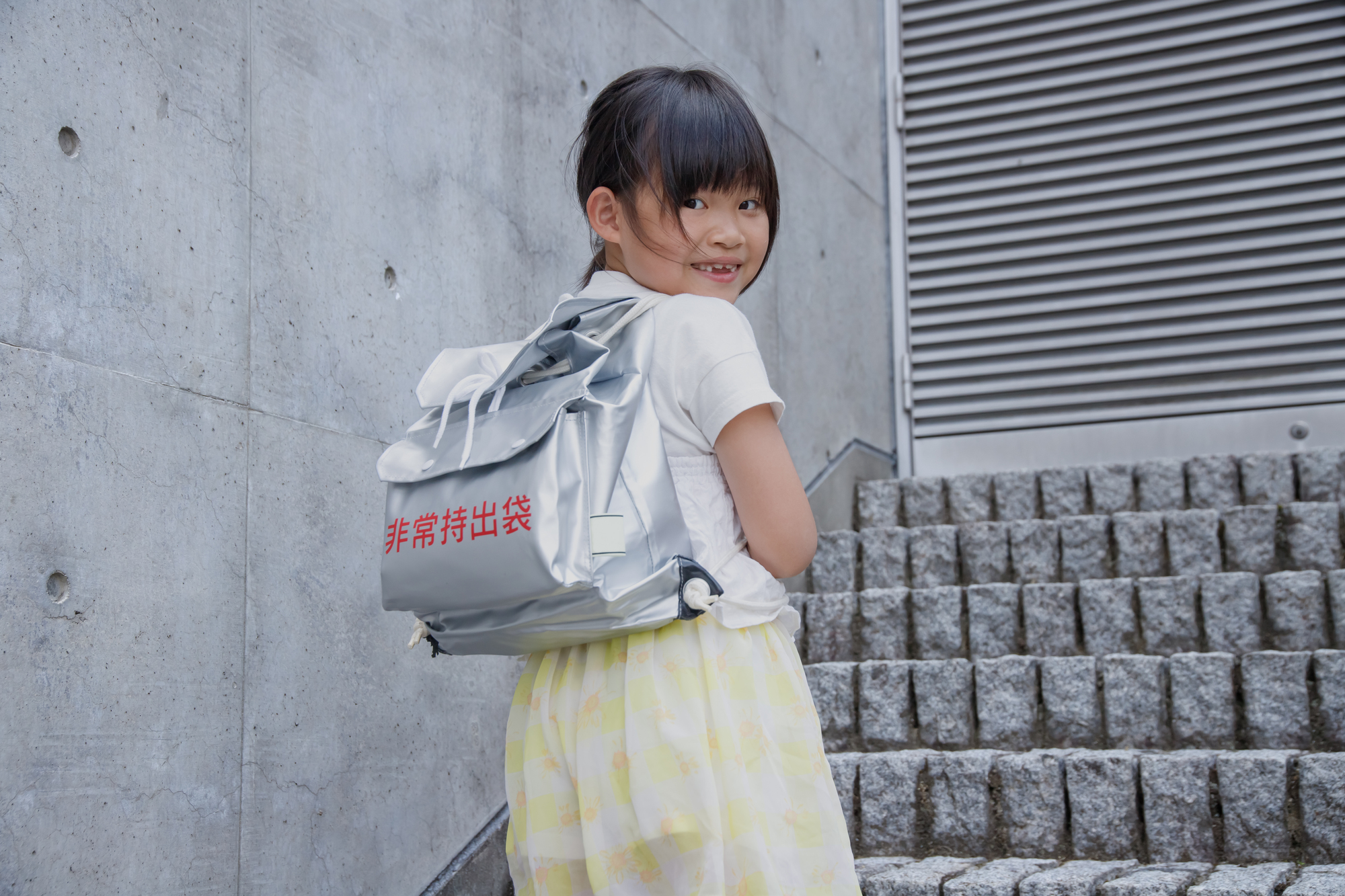 非常用袋を背負う子ども