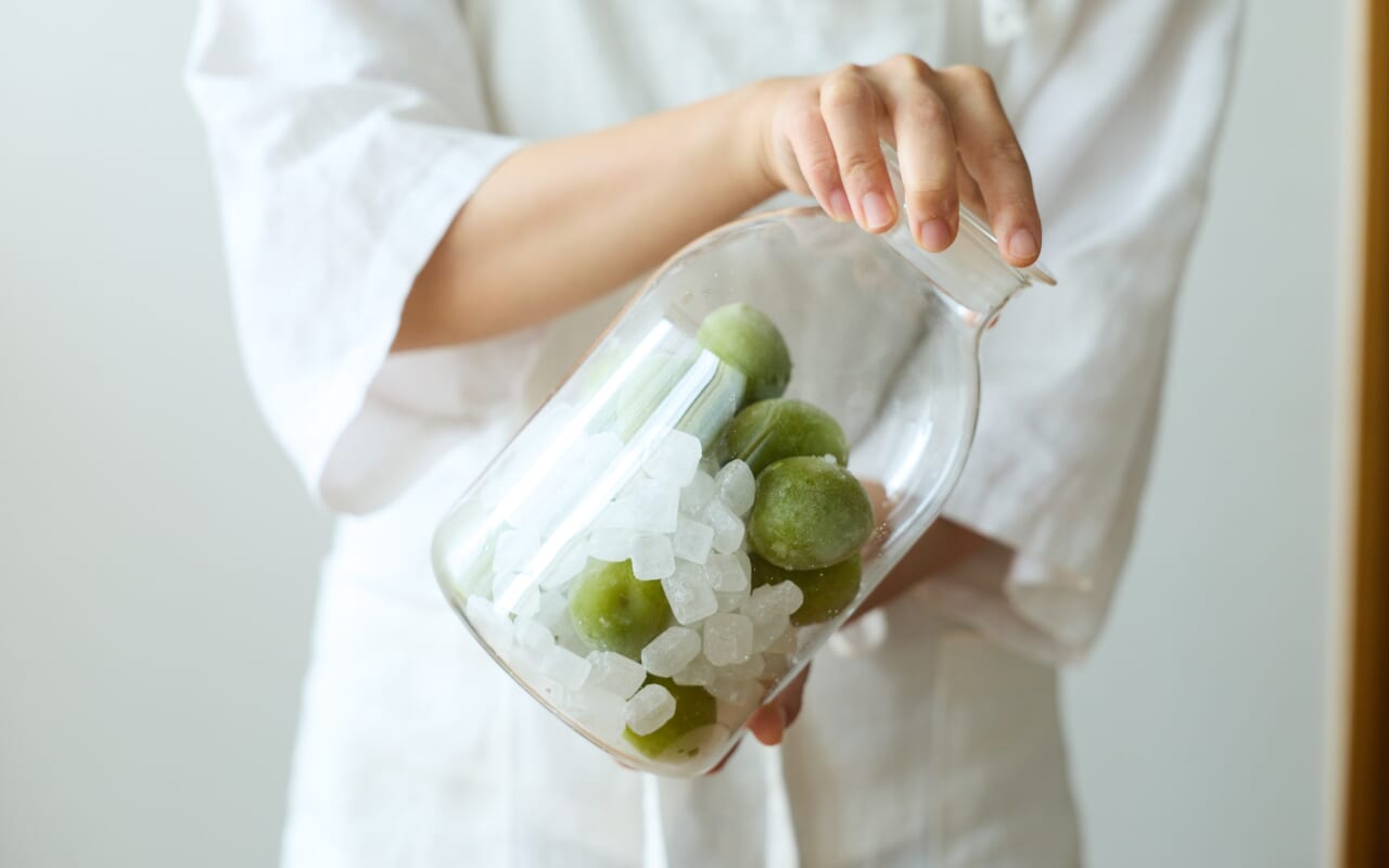 梅と砂糖を瓶の中で混ぜる様子