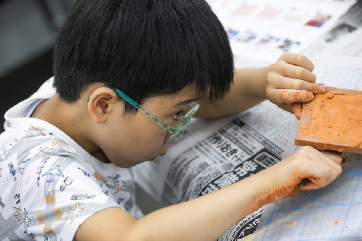 型に伸ばした粘土をはがす男の子