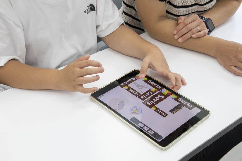 セリアのロゴマークを多く使ってゲームをつくる子どもの様子
