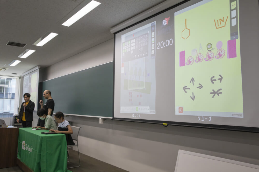 会場前方のスクリーンに写しだされた開始10分の画面の様子。