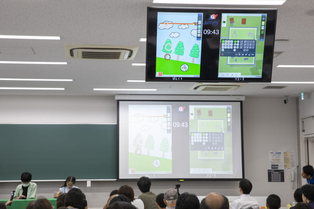 バトル画面を会場全体で観戦する様子。