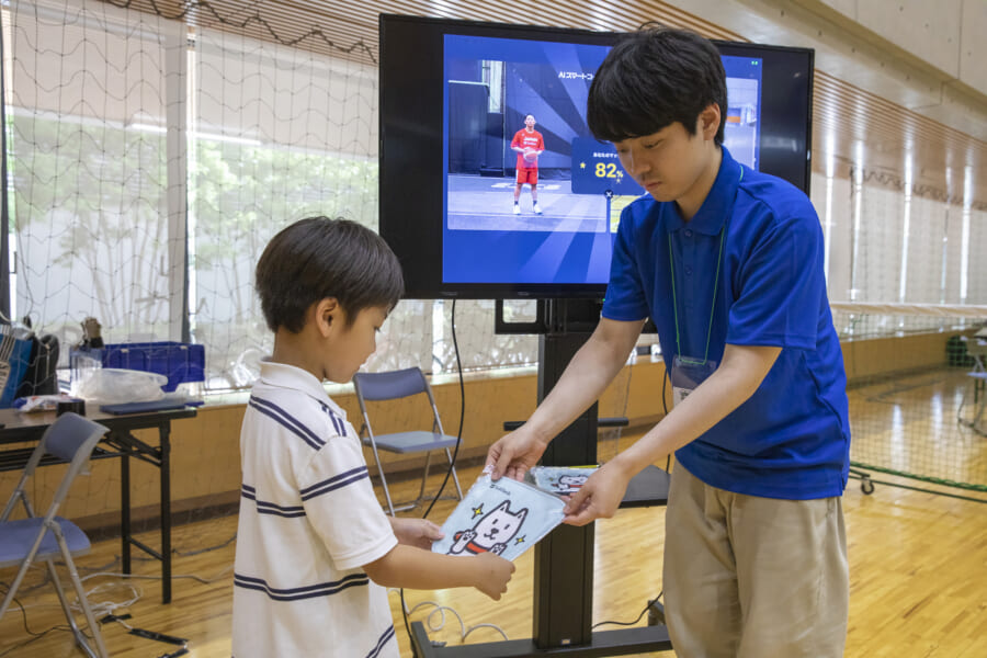 ノベルティのハンカチをスタッフから渡される子ども
