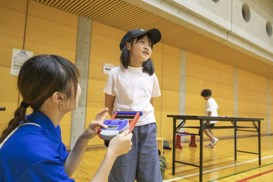 握力測定が終わり顔を上げる女の子