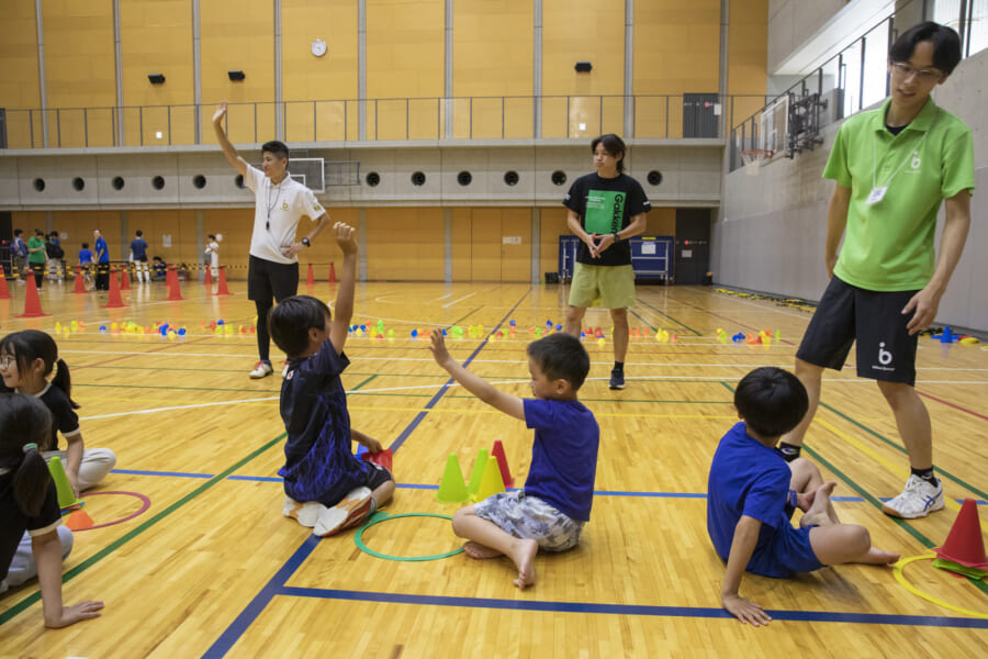走ったあとに取ったコーンの数で手を上げる子どもたち
